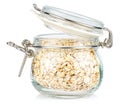 Dry rolled oats in a open transparent glass jar with rubber seal and metal clamp on lid isolated on white background Royalty Free Stock Photo