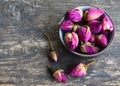 Dry rose buds flowers in a bowl on old wooden table.Healthy herbal drinks concept.Asian ingredient for aromatherapy tea. Royalty Free Stock Photo