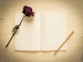 Dry rose and notebook paper with pencil Royalty Free Stock Photo