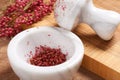 Dry rose pepper in white marble mortar next pestle Royalty Free Stock Photo