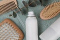 Dry shampoo sprays, hairbrushes and eucalyptus branch on towel, flat lay Royalty Free Stock Photo