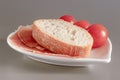 Dry Spanish ham, jamon, Italian ham, chopped layers with bread and cherry tomatoes on a white heart-shaped plate Royalty Free Stock Photo