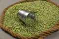 Dry split peas and a small bucket against a gray background. The green beans are framed by the ship`s rope. Close-up. Selective