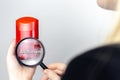 A woman examines the harmful ingredients of the antiperspirant a magnifying glass. Dry stick deodorant stick with Aluminum. The