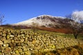 Dry stone wall leading to a snow-covered Herdus fell near Ennerdale Water in the Lake District Royalty Free Stock Photo