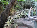 Secret Path in Garden With Steps and Wooden Rail Branch and Stonework Royalty Free Stock Photo