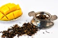 Dry tea herbs with fruit and fresh mango on white background. Selective focus Royalty Free Stock Photo