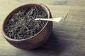 Dry tea in wooden plate on wooden table. Royalty Free Stock Photo