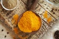 Dry turmeric root powder in a spoon with ground and whole black pepper Royalty Free Stock Photo