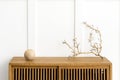 Dry twig on a wooden cabinet in a white room Royalty Free Stock Photo