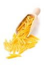 Dry, uncooked, raw penne pasta noodles in wooden scoop Royalty Free Stock Photo