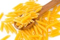 Dry, uncooked, raw penne pasta noodles in wooden spoon Royalty Free Stock Photo