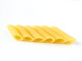 Dry uncooked yellow Italian penne pasta arranged neatly isolated on a white background. Royalty Free Stock Photo