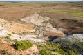 A dry watercourse flowing onto a flood plain