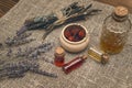 Dry wild berry essential oil and lavender flowers on the sackcloth burlap background. Royalty Free Stock Photo