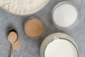 Dry yeast, sugar, flour, and milk on grey marble background, flat lay. Ingredients for baking needs close up Royalty Free Stock Photo