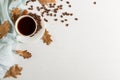Dry yellow leaves, blue scarf, coffee grains and a cup on a white table, morning start day. Autumn mood background, copy space, Royalty Free Stock Photo