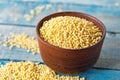 Dry yellow millet in a bowl on a background of old blue boards