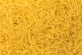 Dry yellow pasta everywhere. Background. Close up