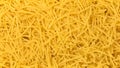 Dry yellow pasta everywhere. Background. Close up.