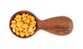 Dry yellow split peas in wooden spoon, isolated on white background. Halves of yellow legume peas. Top view.