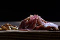 Dryed meat with nuts on a old chopping board.