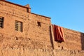 Drying carpet on the earthen walls of the house