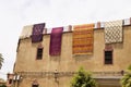 Drying carpets on the earthen walls of the house, Morocco