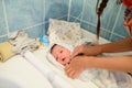 Drying of the child after a bath. bathing newborn. Cute newborn girl, a boy in a towel after a bath with his mother`s hands dryly Royalty Free Stock Photo