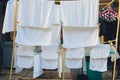 Drying clothes in the unusual sunset. White towels and sheets dry in the sun on stretched laundry ropes. Washing laundry Royalty Free Stock Photo