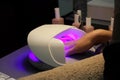 Drying and fixing a transparent base base applied to the nails before using shellac with an ultraviolet lamp Royalty Free Stock Photo