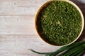 Dehydrator grid with dried spring green onion feathers on a light wooden background. Royalty Free Stock Photo