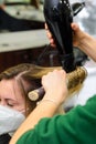 Drying hair with a hair dryer and a round brush, hairdressing procedures.