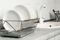 Drying rack with clean dishes on kitchen counter. Royalty Free Stock Photo