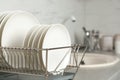 Drying rack with clean dishes on kitchen counter. Royalty Free Stock Photo
