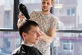 Drying, styling men`s hair in a beauty salon
