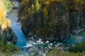 Drying up blue river flows deep in the canyon against the autumn forest. Royalty Free Stock Photo