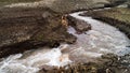 Drying up stream. Shot. Cracking clay on surface of ground near drying stream. Small river flows through dry clay area