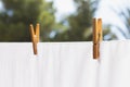 Drying white cloth on rope and fastened with wooden clothespins in sunlight Royalty Free Stock Photo