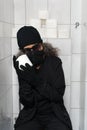 Burglar with highly coveted Toilet paper roll sitting on toilet Royalty Free Stock Photo