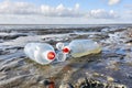 Plastic bottles with red bottle caps on a beach Royalty Free Stock Photo