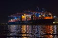 Illuminated container ship at night