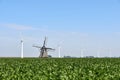 Modern wind turbines behind an old traditional windmill Royalty Free Stock Photo
