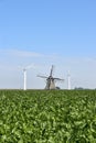 Modern wind turbines behind an old traditional windmill Royalty Free Stock Photo