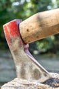 Axe with traces of red paint impaled in log Royalty Free Stock Photo