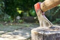 Axe with traces of red paint impaled in log Royalty Free Stock Photo