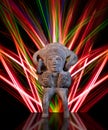 South-American Deity in clay. Colorful neon lights in the background.