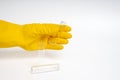 Hand in yellow glove holding clear liquid bottle on isolated white background. Close-up view of transparent bottles Royalty Free Stock Photo