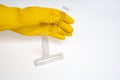 Hand in yellow glove holding clear liquid bottle on isolated white background. Close-up view of transparent bottles Royalty Free Stock Photo