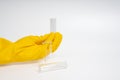 Hand in yellow glove holding clear liquid bottle on isolated white background. Close-up view of transparent bottles Royalty Free Stock Photo